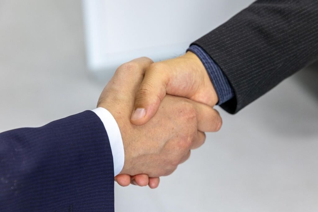 Professional handshake representing link building construction singapore partnerships