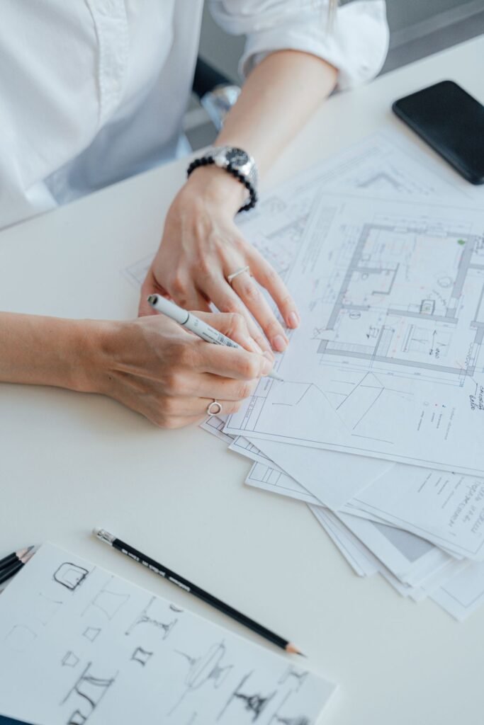 Architect writing on floor plans representing seo content construction singapore writing