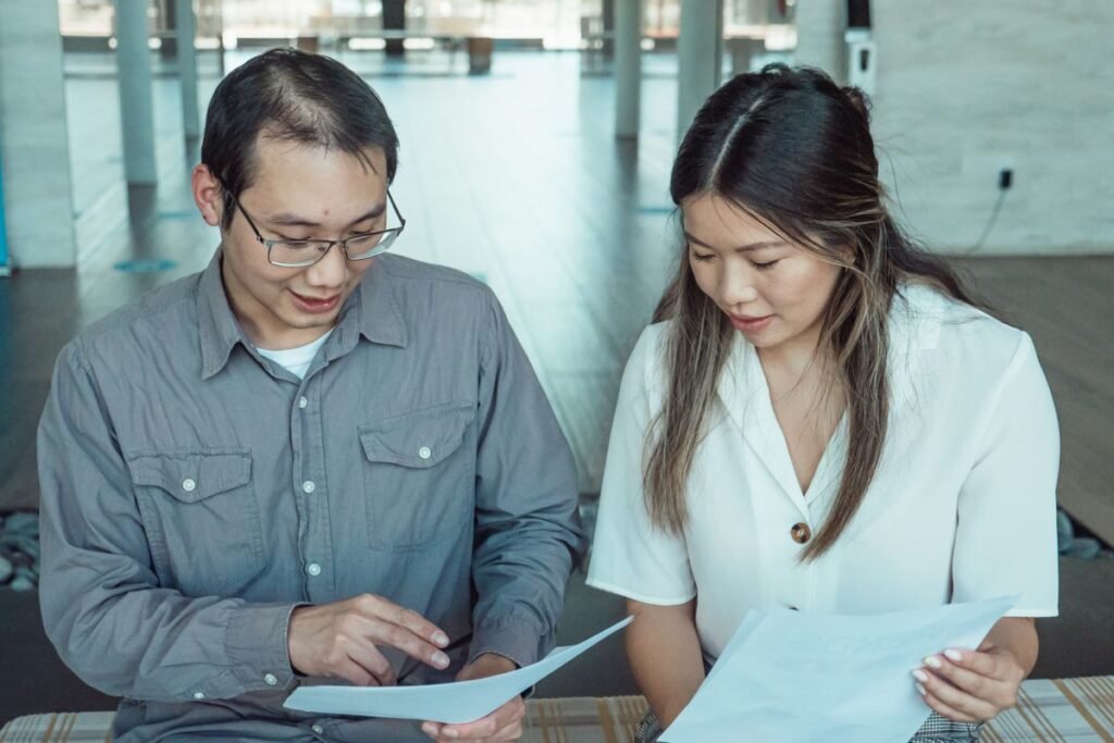 Two colleagues reviewing a printed report together, illustrating the difference between link building and backlinks
