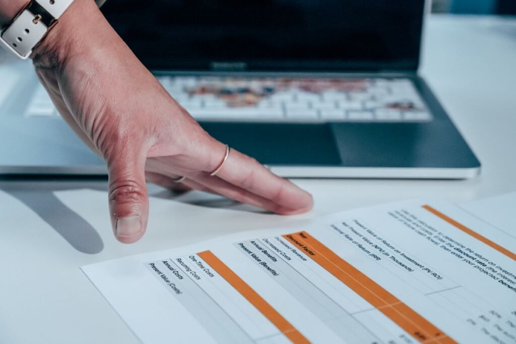 Hand reviewing a printed link report beside a laptop during a backlink audit free of paid tools