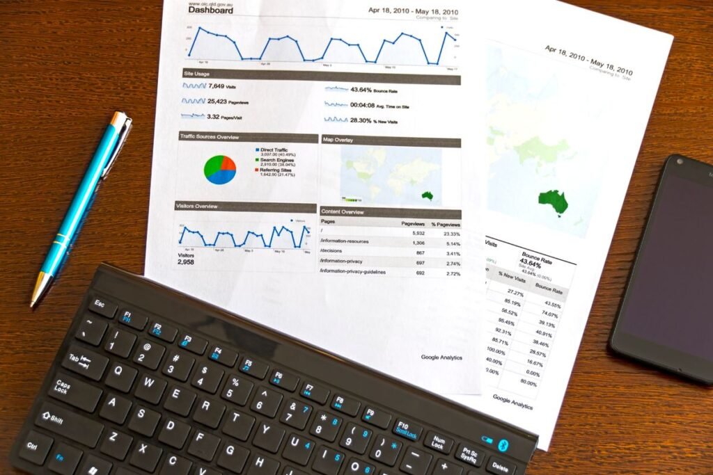 Printed analytics charts beside a keyboard, used to review bounce rate by landing page