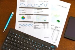 Printed analytics charts beside a keyboard, used to review bounce rate by landing page