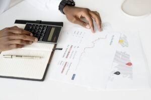 Person using a calculator over printed charts to work out a click through rate formula