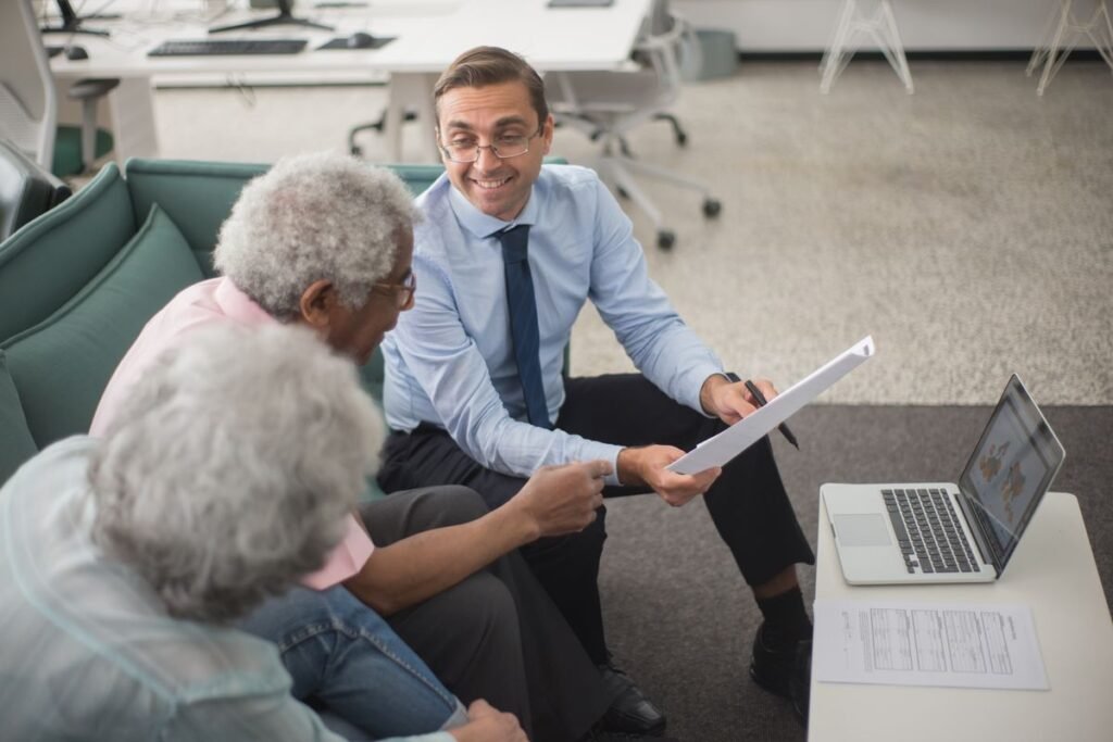 Financial adviser discussing a plan with senior clients, showing digital marketing for insurance agents