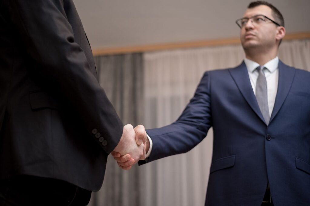 Two businesspeople shaking hands over a deal, where domain authority is often used as a sales promise