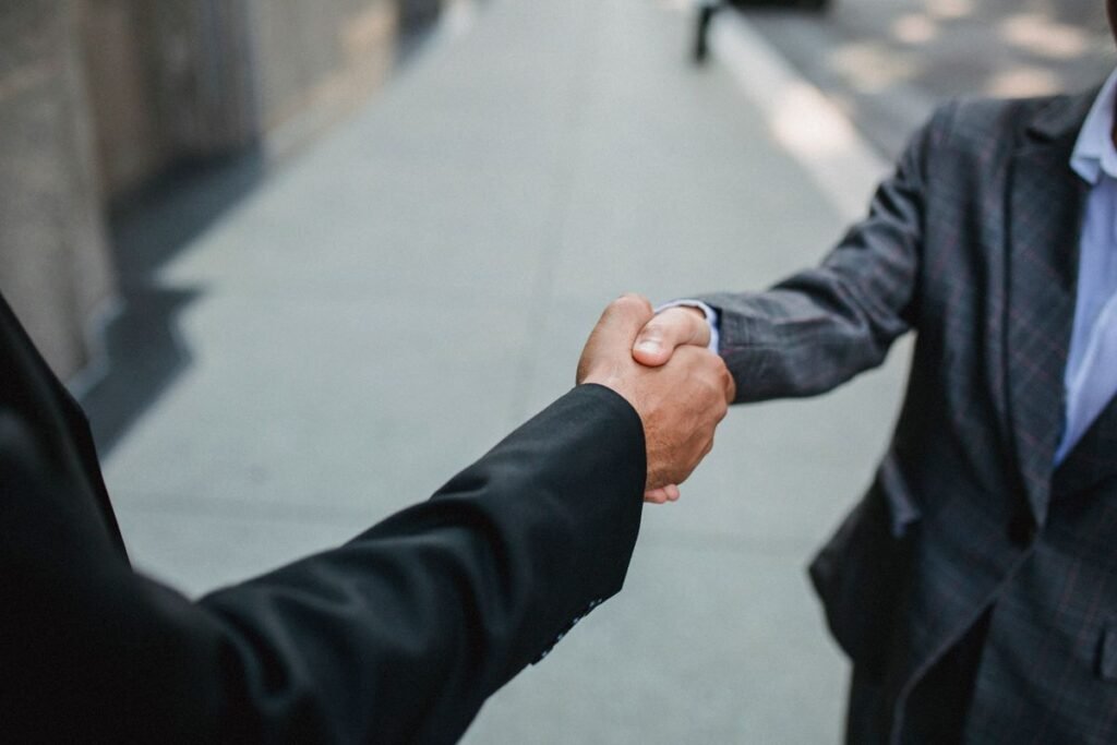 Two business partners shaking hands, representing free backlinks earned from existing relationships