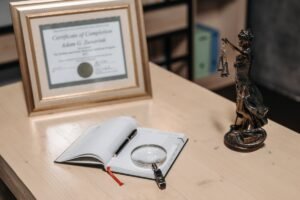 Framed certificate on an office desk beside a notebook, representing a google analytics certification