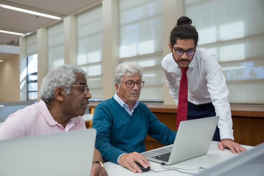 Trainer guiding two learners at laptops during a google analytics course singapore session