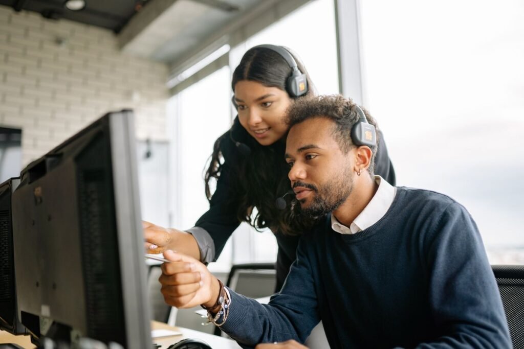 Colleague helping a coworker at a desktop computer, getting google search console help