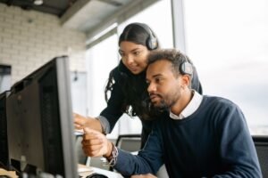 Colleague helping a coworker at a desktop computer, getting google search console help
