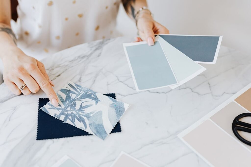 Interior designer selecting fabric and colour swatches, illustrating how to market interior design business