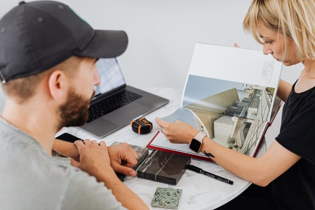 Two interior designers discussing plans at a table, showing marketing for interior design company growth