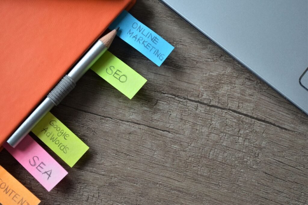 Sticky notes labelled with SEO terms beside a laptop, planning work in an SEO keyword research tool