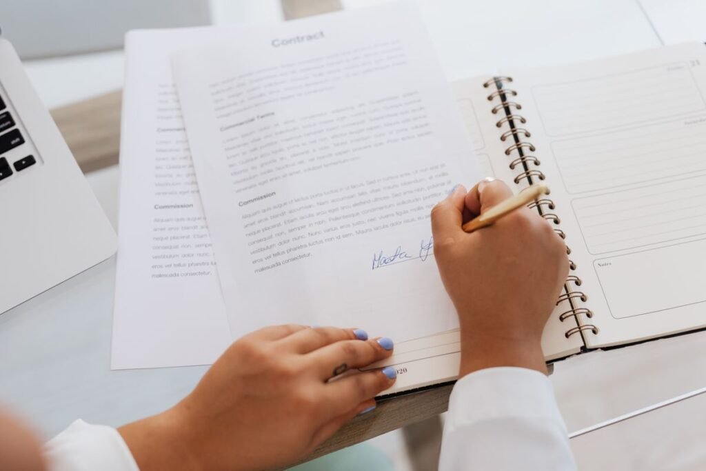 Hand signing a contract document, representing the terms of an SEO retainer