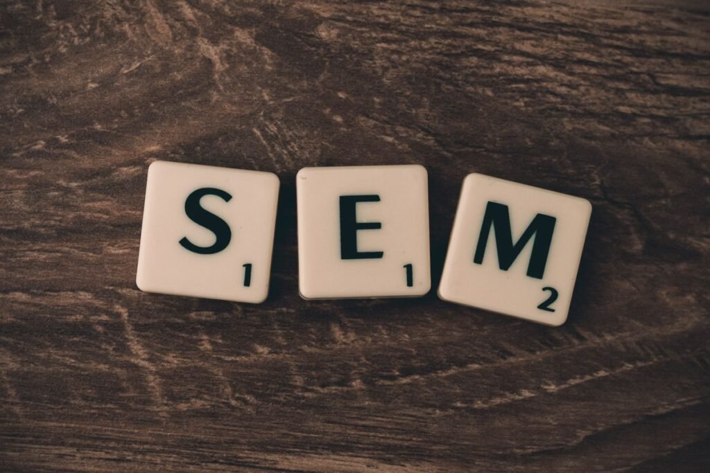 Letter tiles spelling SEM on a wooden table, representing the SEO vs SEM question